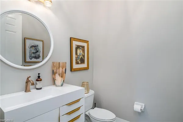 a bathroom with a toilet a sink and mirror