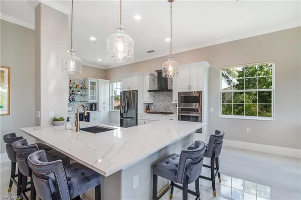 a kitchen with stainless steel appliances a dining table chairs and wooden floor
