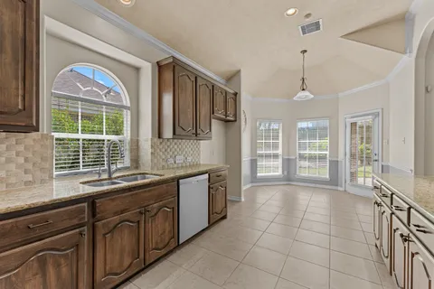 a kitchen with granite countertop cabinets stainless steel appliances and wooden floor