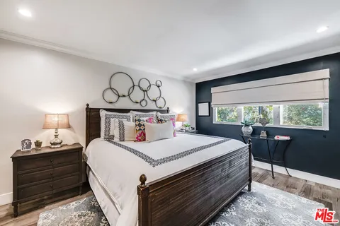 a view of a patio with table and chairs potted plants and a large tree