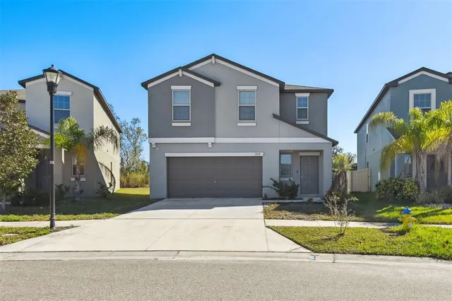a front view of a house with a yard and garage