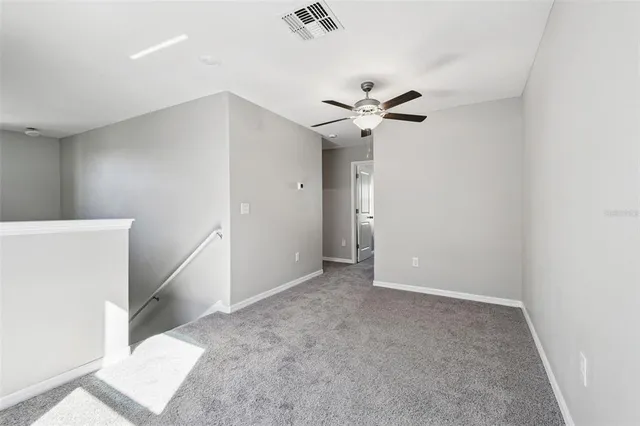 an empty room with a window and a fan