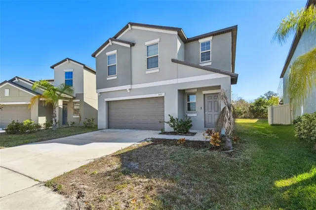 a front view of a house with a yard and garage
