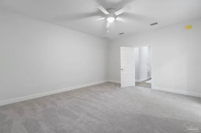 an empty room with a ceiling fan and a fan