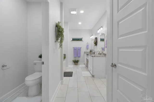 a bathroom with a sink and mirror with toilet