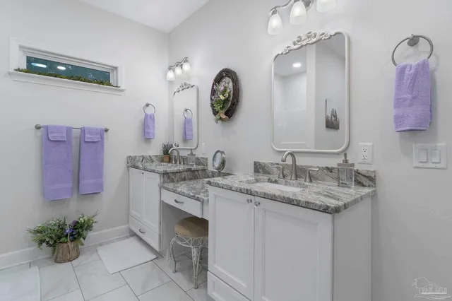 a bathroom with a granite countertop sink a potted plant and a mirror