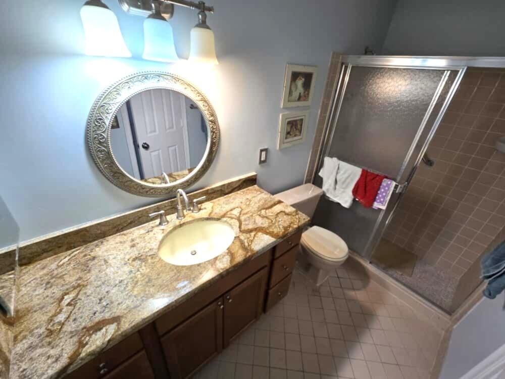 6045 Stanley Lane Delray Beach, FL 33484 - Photo 4 of 4 a bathroom with a granite countertop sink and a mirror