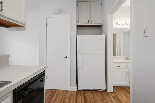 a kitchen with white cabinets and a refrigerator