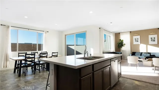a kitchen with a dining table chairs and white cabinets