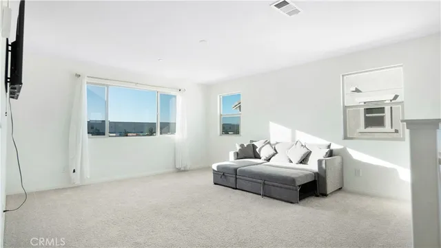 a living room with furniture and view of kitchen