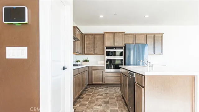 a kitchen with kitchen island granite countertop a sink stove and refrigerator