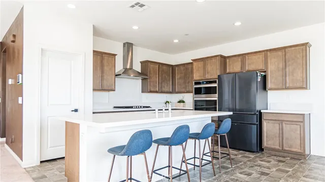 a kitchen with kitchen island a refrigerator stove and sink