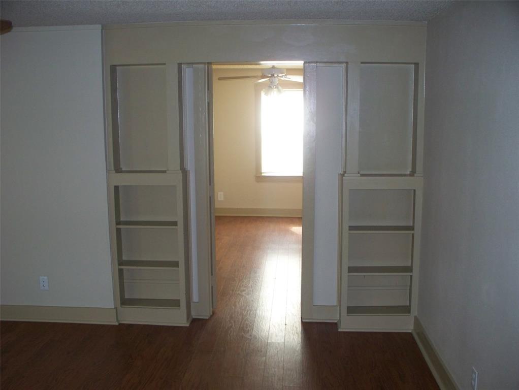 705 South Street, Unit A Graham, TX 76450 - Photo 5 of 7 an empty room with wooden floor closet and windows