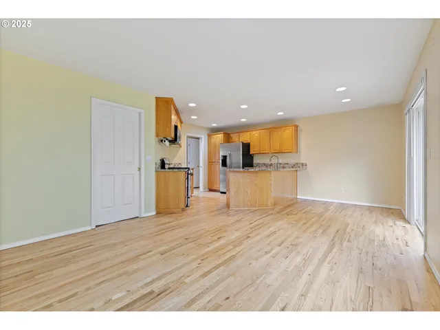 a view of a big room with wooden floor and a window