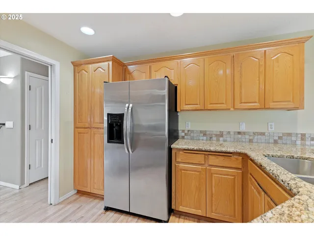a kitchen with stainless steel appliances granite countertop a refrigerator and a sink