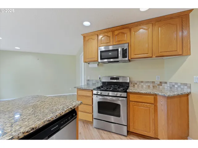 a kitchen with stainless steel appliances granite countertop a stove and a microwave