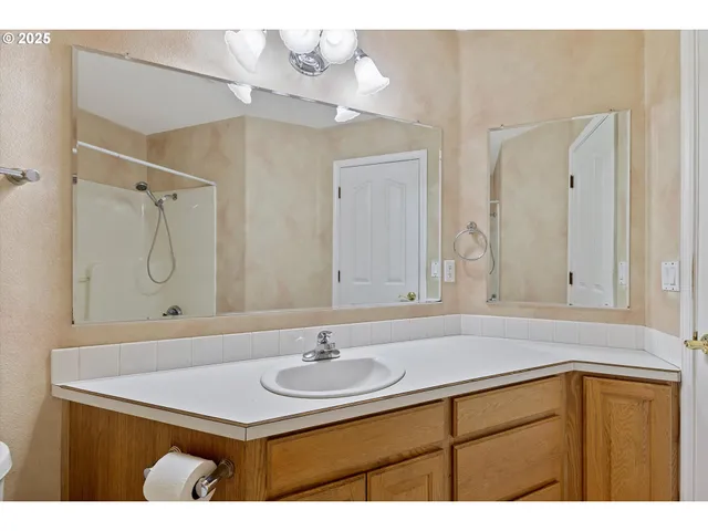 a bathroom with a sink vanity granite and a mirror