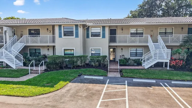 a sign of golf club on a wall under a tree