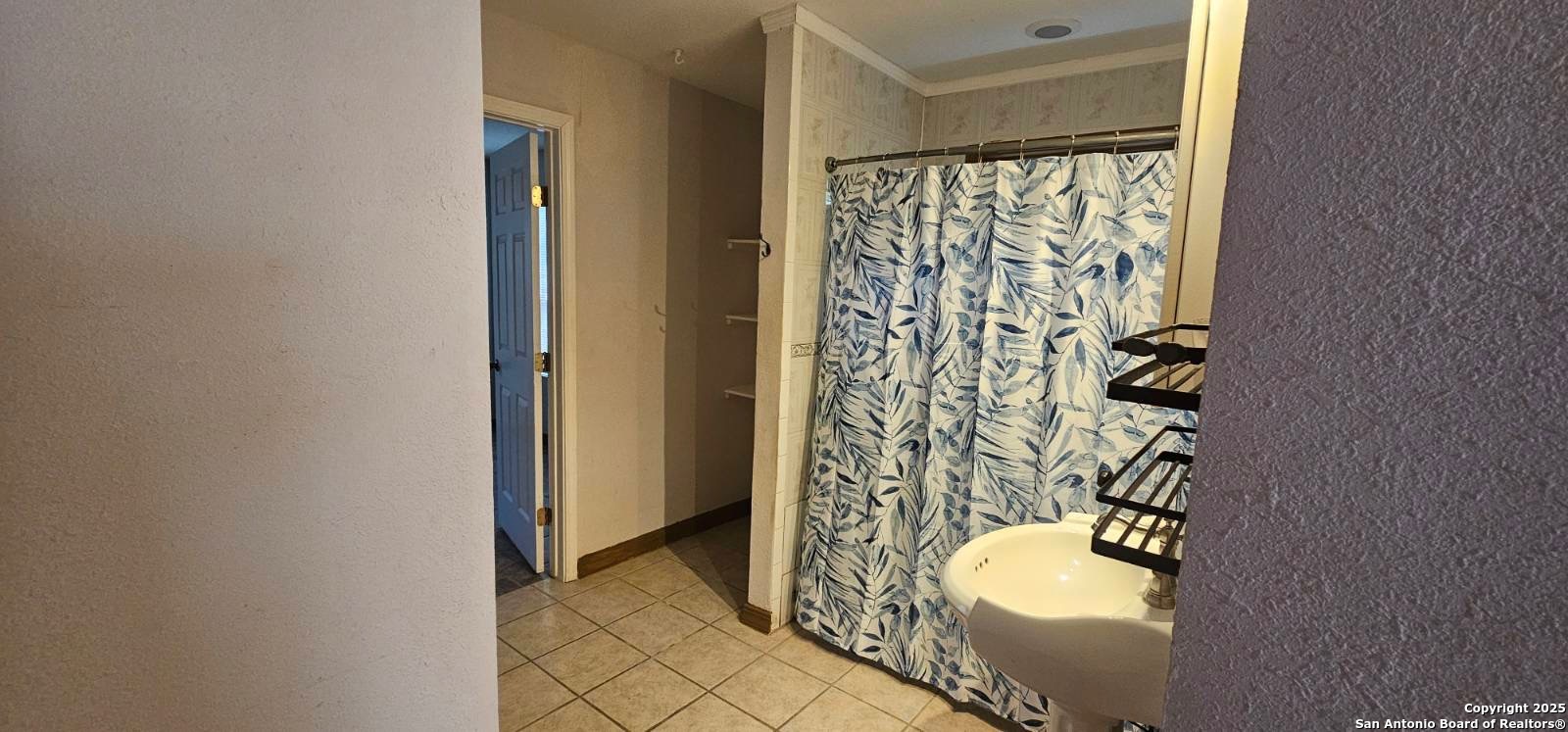 111 Rene Avenue San Antonio, TX 78233 - Photo 12 of 15 a bathroom with a granite countertop sink and a shower curtain