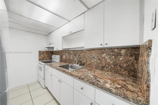 a kitchen with stainless steel appliances granite countertop a sink and a white cabinets