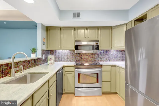 a kitchen with stainless steel appliances granite countertop a refrigerator sink and stove