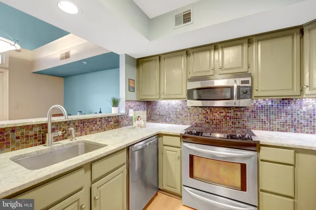 a kitchen with stainless steel appliances granite countertop a sink stove and microwave