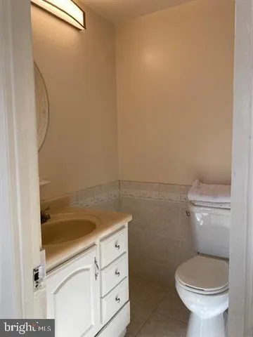 a bathroom with a granite countertop toilet and a sink