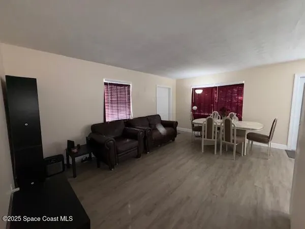 a living room with furniture a dining table and a piano