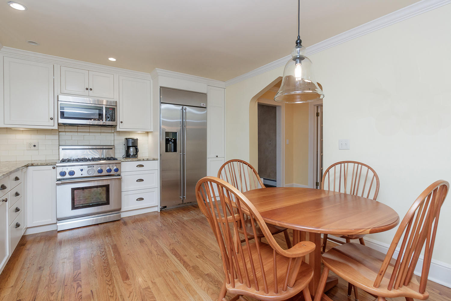 8 Abbey Road Darien, CT 06820 - Photo 13 of 39 a kitchen with stainless steel appliances kitchen island granite countertop a stove a sink a dining table and chairs with wooden floor