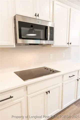 a kitchen with stainless steel appliances white cabinets and a microwave oven