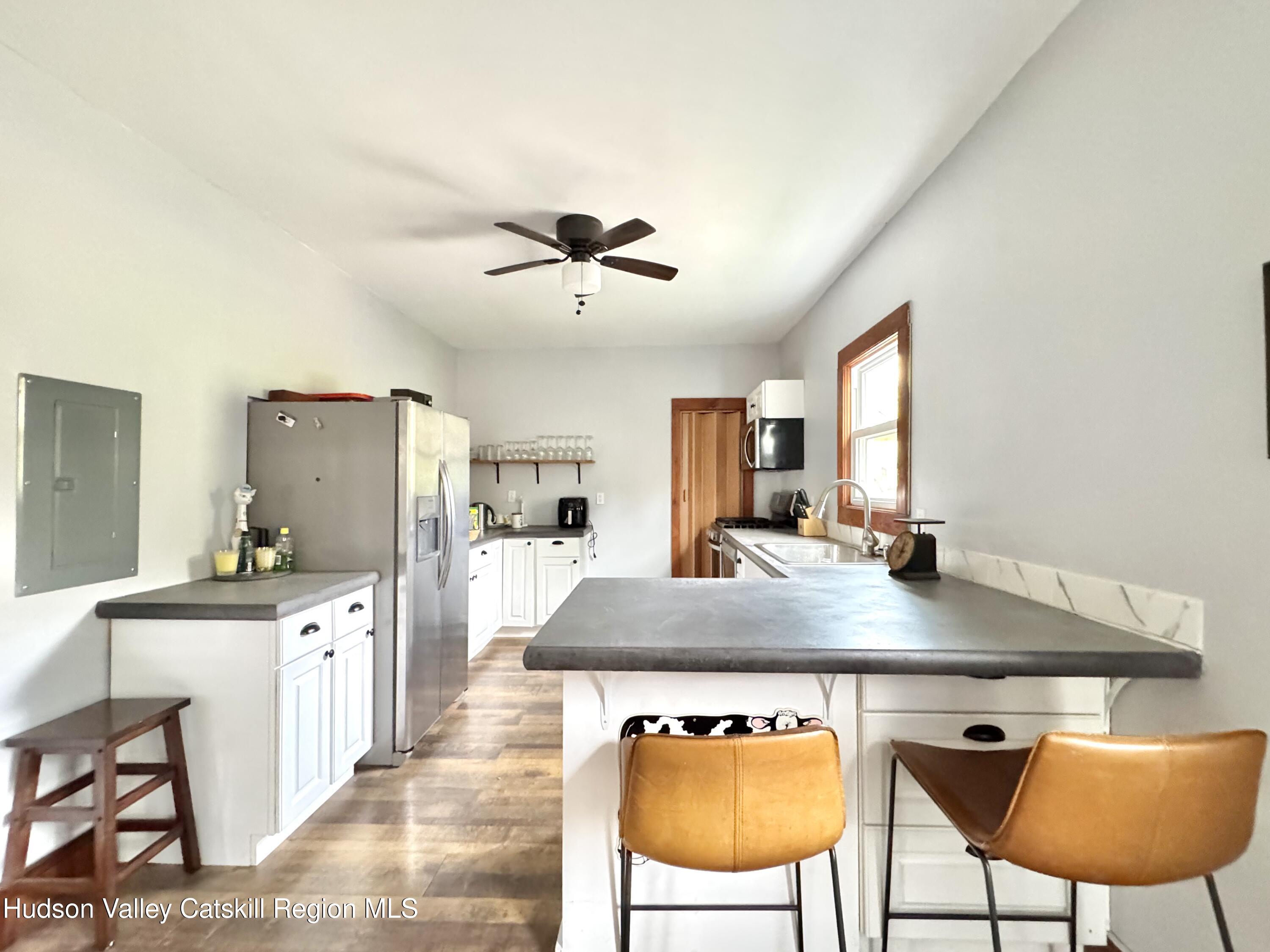 1114 Main Street Catskill, NY 12451 - Photo 9 of 40 a view of a kitchen with kitchen island a table and chairs in it