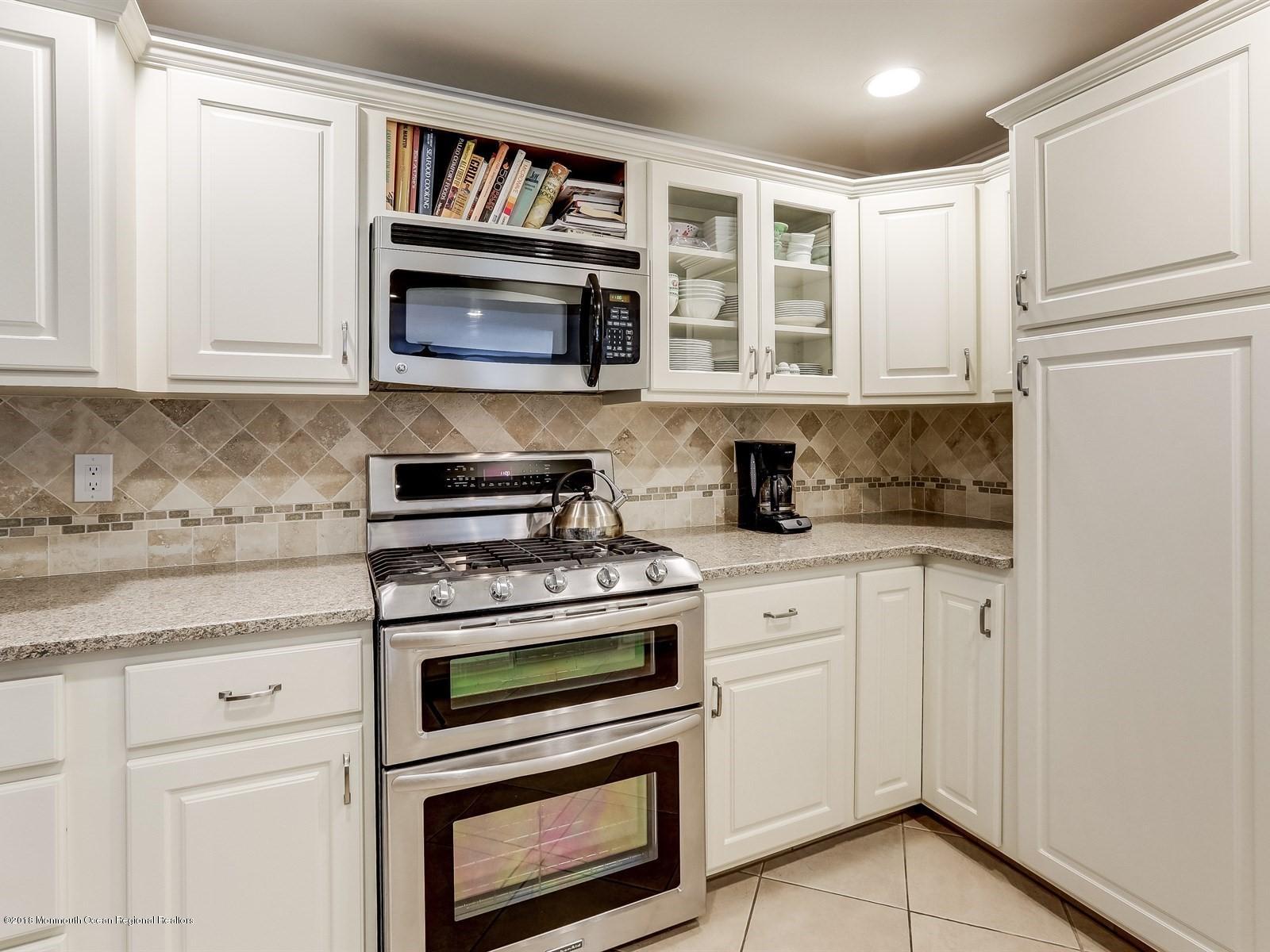 16 Rivers Edge Drive Little Silver, NJ 07739 - Photo 8 of 33 a kitchen with stainless steel appliances granite countertop white cabinets and a stove top oven