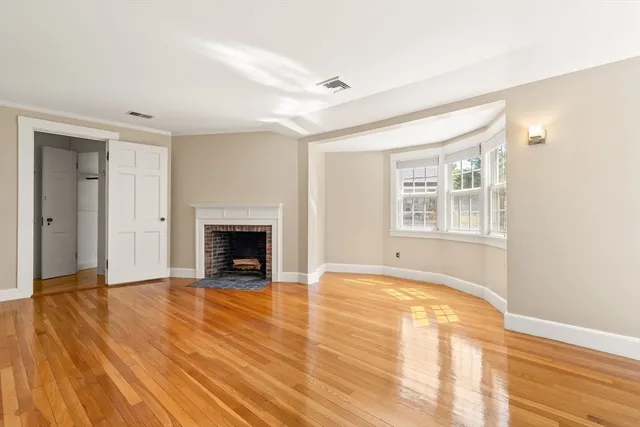 a view of an empty room with a window and fireplace