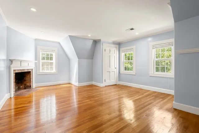 a view of empty room with wooden floor and fireplace