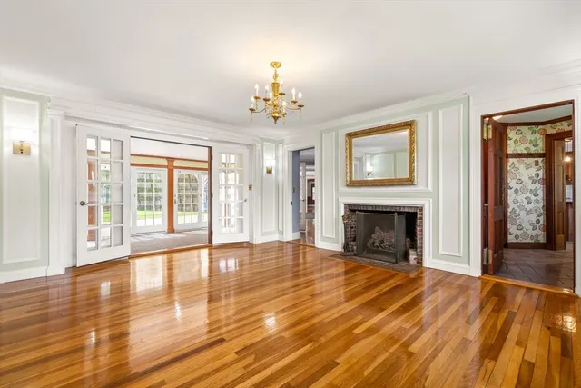 a view of an empty room with glass door and wooden floor