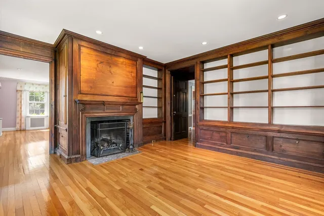 a view of an empty room with window and fire place
