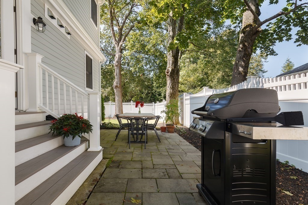 3 Garrison Road Wellesley, MA 02482 - Photo 31 of 36 a view of a patio with table and chairs and floor to ceiling window with wooden fence
