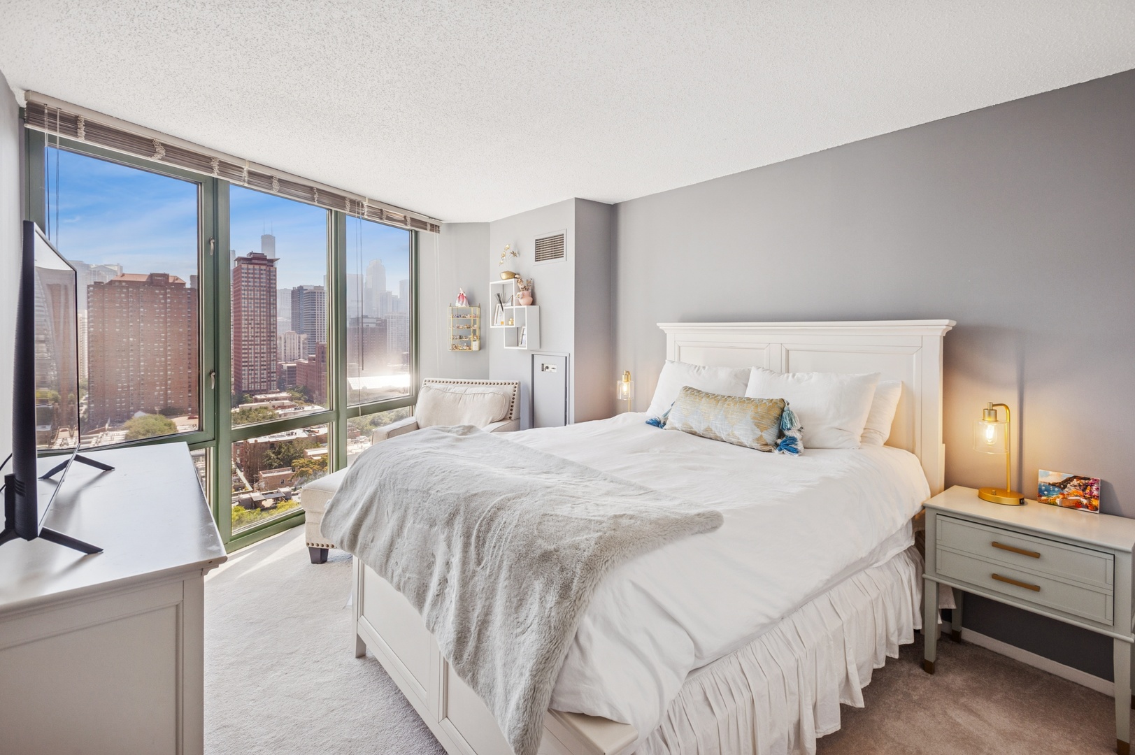 111 West Maple Street, Unit 1704 Chicago, IL 60610 - Photo 12 of 24 a bedroom with a bed a lamp and large window