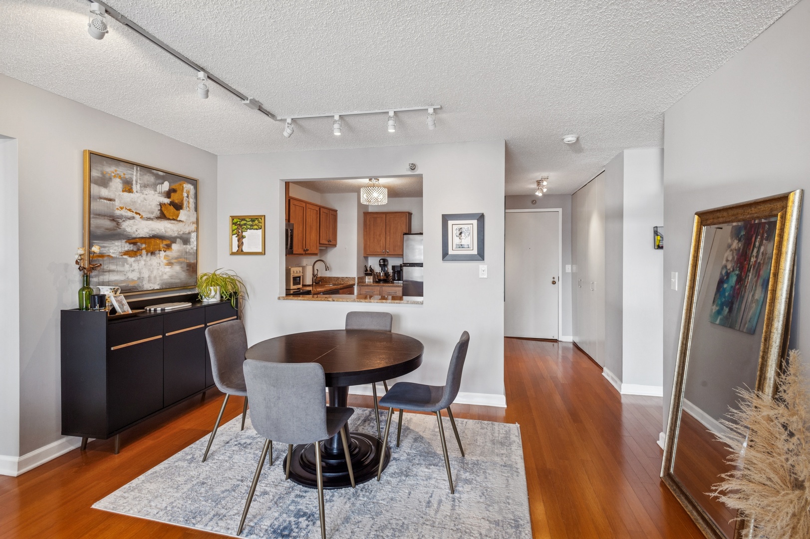 111 West Maple Street, Unit 1704 Chicago, IL 60610 - Photo 5 of 24 a dining room with stainless steel appliances kitchen island granite countertop furniture and a refrigerator