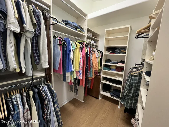 a view of walk in closet with clothes and shoes