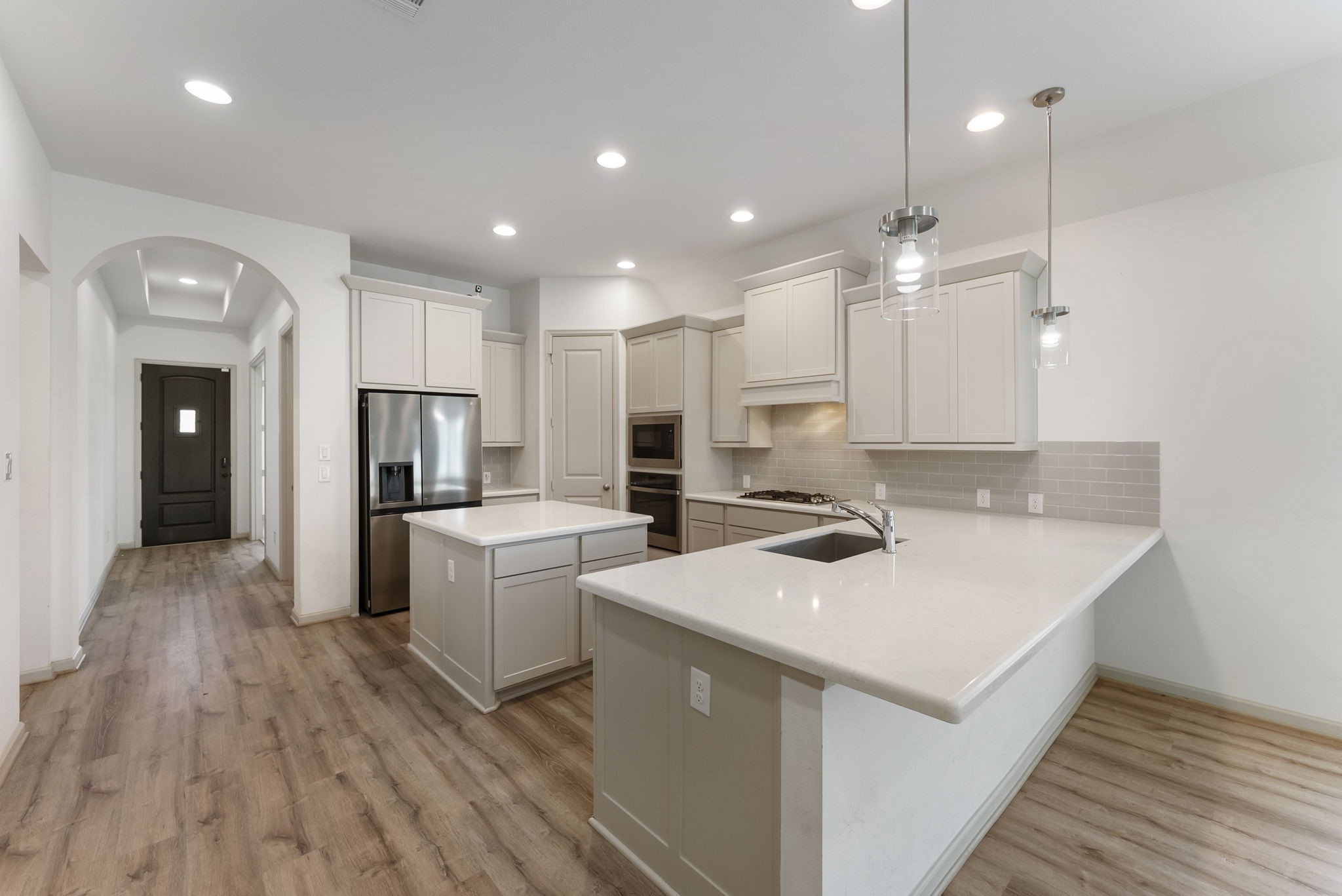 17192 Wild Robin Lane Conroe, TX 77302 - Photo 4 of 15 a kitchen with a sink a refrigerator and a stove top oven