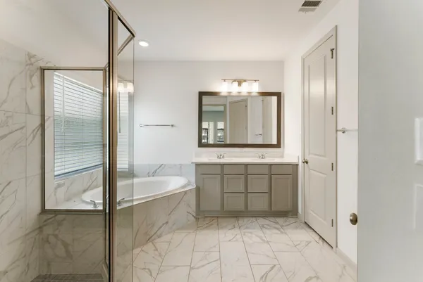 a bathroom with a tub sink and mirror