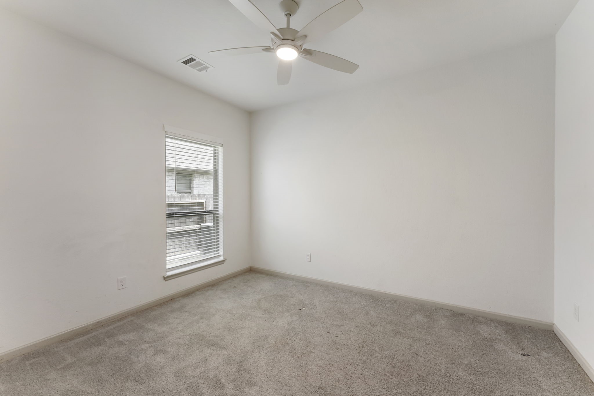 17192 Wild Robin Lane Conroe, TX 77302 - Photo 10 of 15 an empty room with chandelier fan and windows