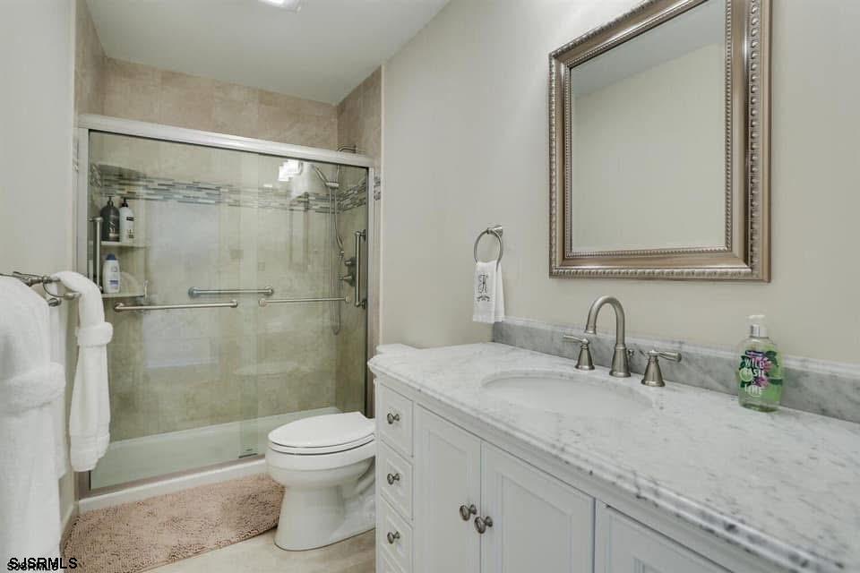 433 Albacore Lane Brigantine, NJ 08203 - Photo 16 of 22 a bathroom with a granite countertop sink a toilet and shower