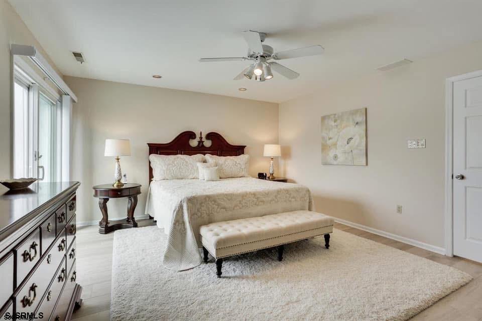 433 Albacore Lane Brigantine, NJ 08203 - Photo 17 of 22 a bedroom with a bed and a chandelier