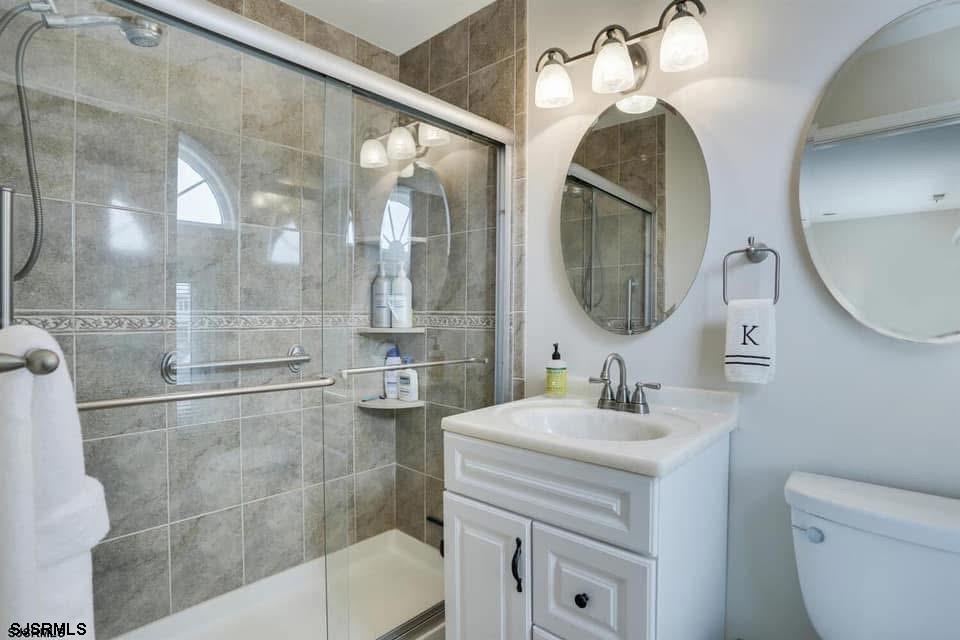 433 Albacore Lane Brigantine, NJ 08203 - Photo 19 of 22 a bathroom with a sink a toilet and a mirror