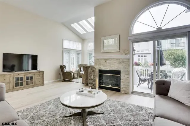 a living room with furniture a flat screen tv and a fireplace