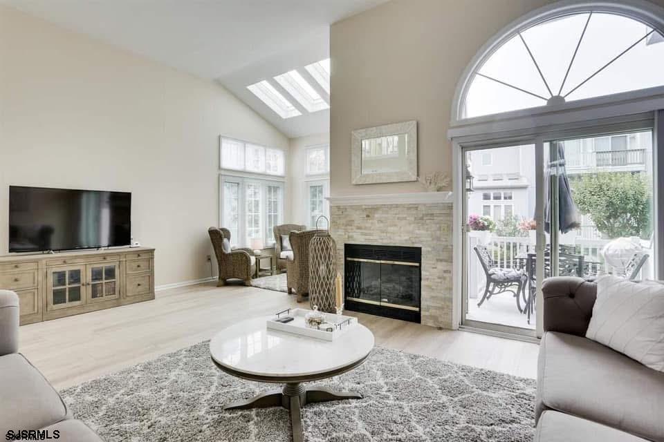 433 Albacore Lane Brigantine, NJ 08203 - Photo 3 of 22 a living room with furniture a flat screen tv and a fireplace
