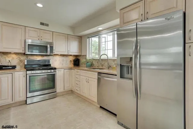 a kitchen with a refrigerator a sink and a stove top oven