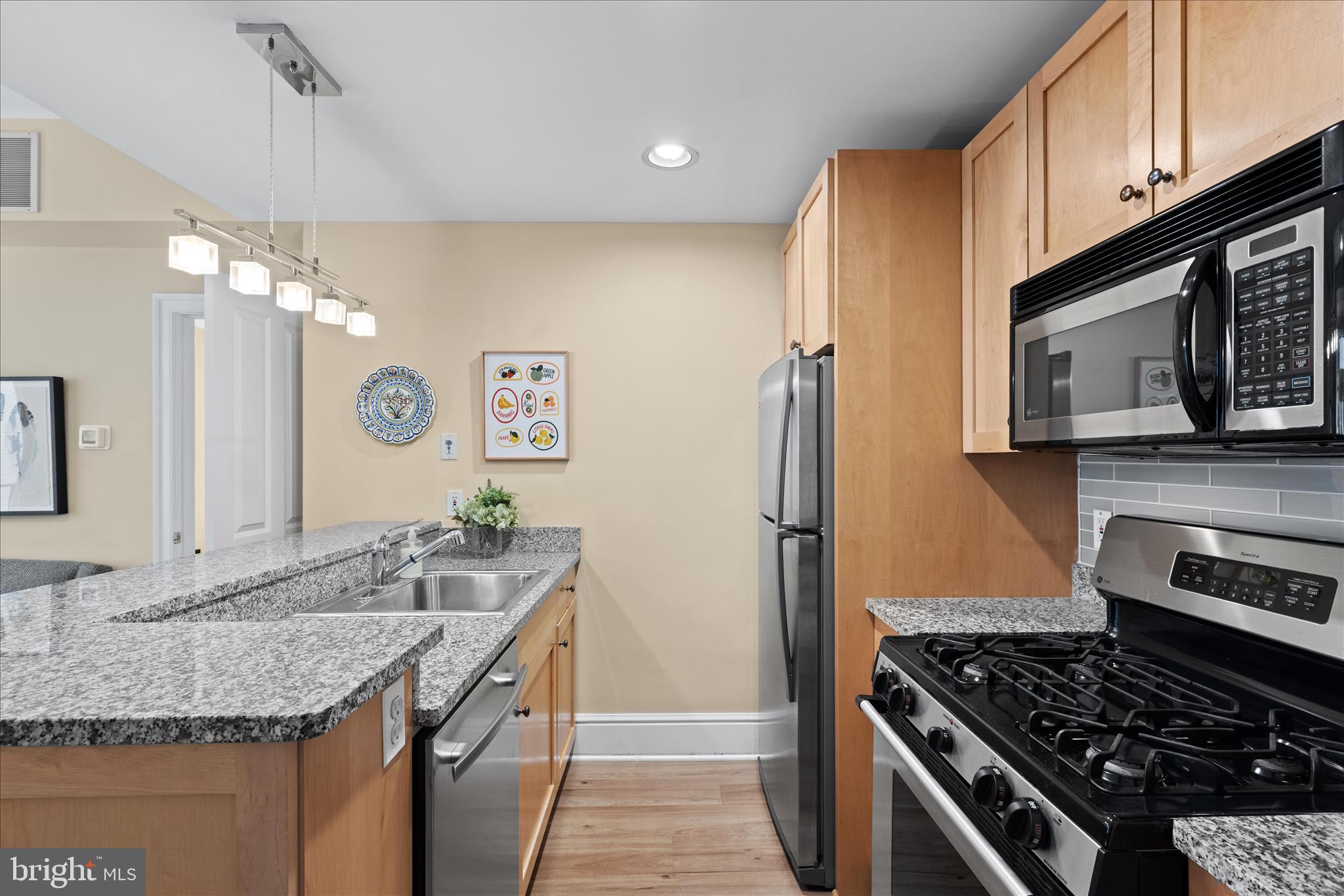 1625 16th Street Northwest, Unit 302 Washington, DC 20009 - Photo 4 of 26 a kitchen with granite countertop stainless steel appliances a sink stove and refrigerator